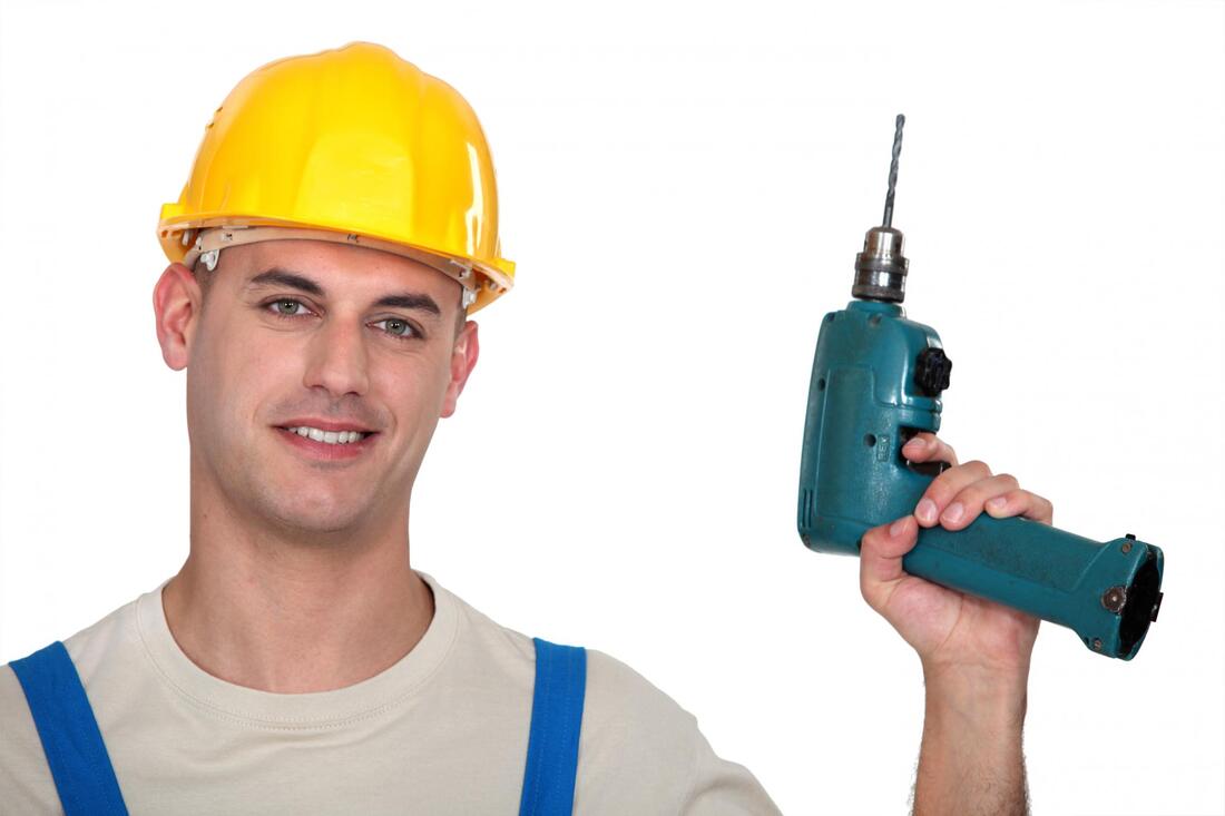 construction man smiling holding a drill 