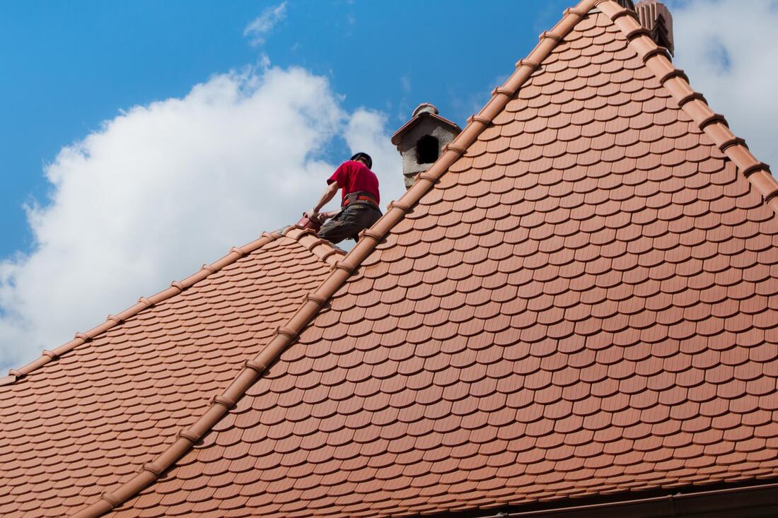 professional roofer working on shingle roofing 